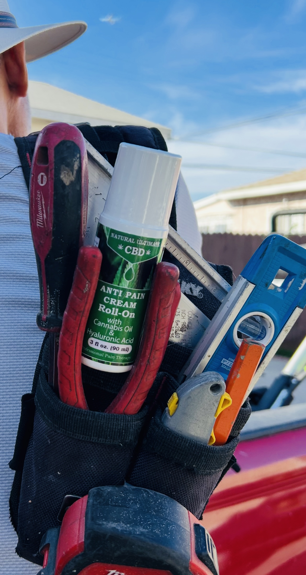 CBD pain relief roll-on stored in a tool belt for easy access during physical work
