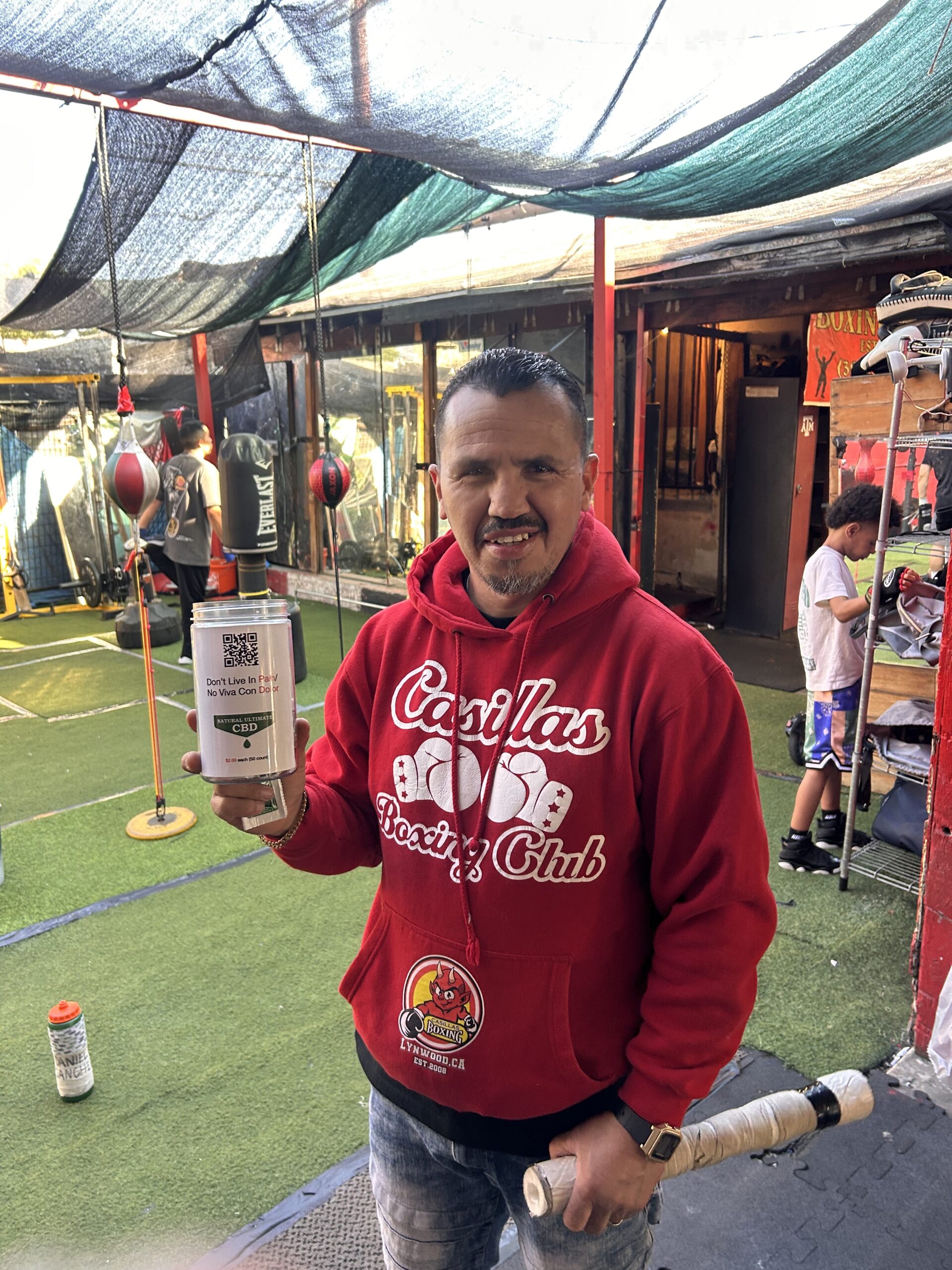 Salvador Casillas at Casillas Boxing Gym in Linwood CA holding topical CBD pain cream after boxing training for muscle recovery