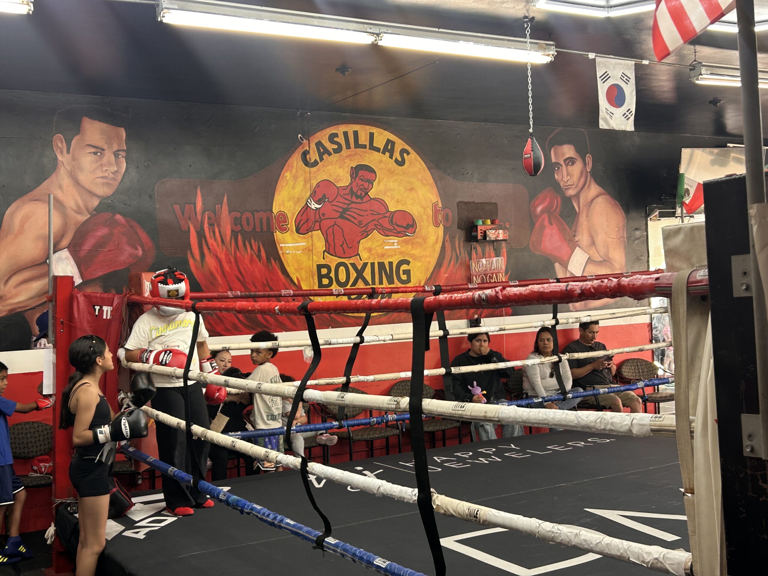 boxing ring inside Casillas Boxing Gym in Linwood California with athletes training and gym mural in background